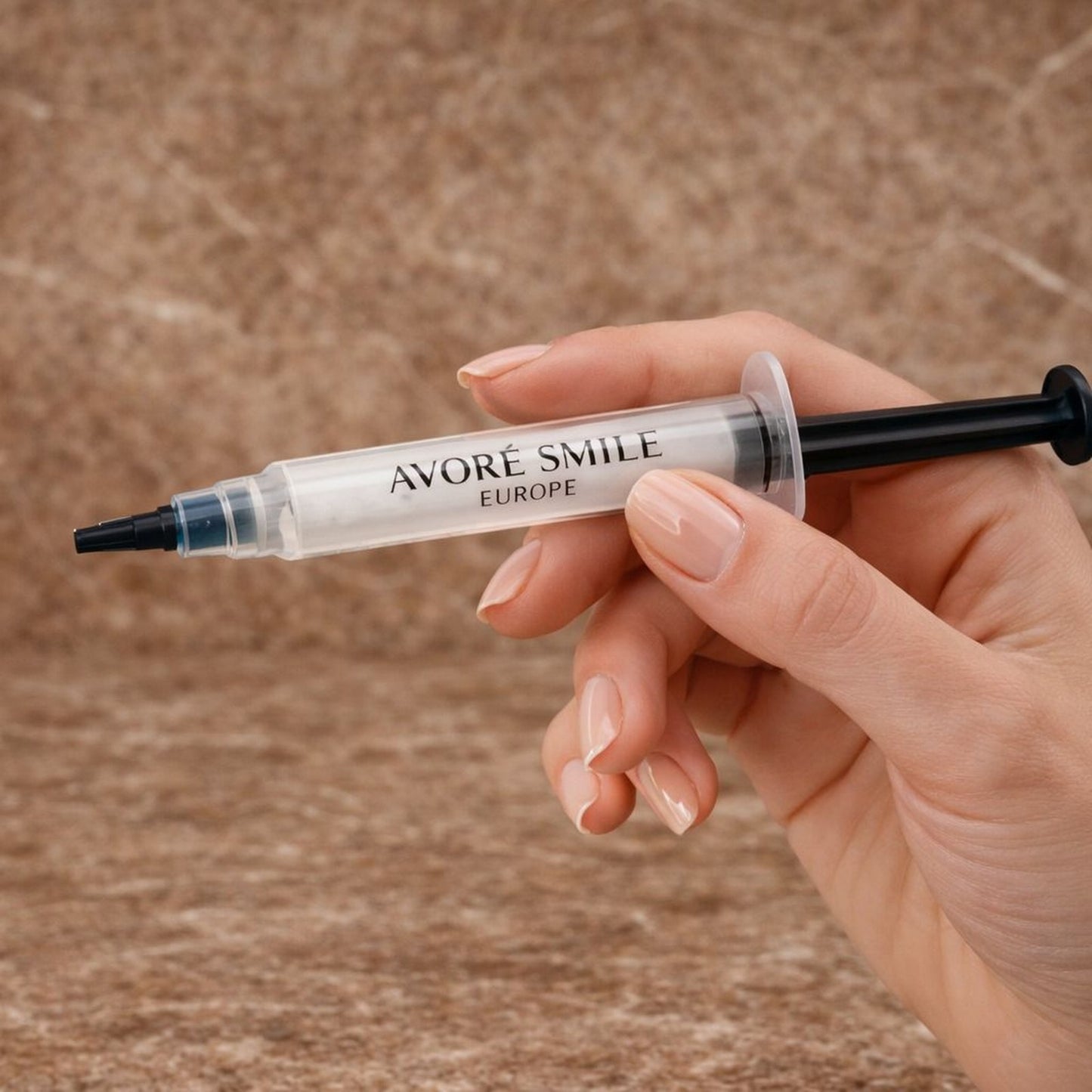 Avoré Smile Europe 12% PAP non-peroxide teeth whitening gel syringe, 3ml dental whitening treatment held in hand with a red marble backdrop 