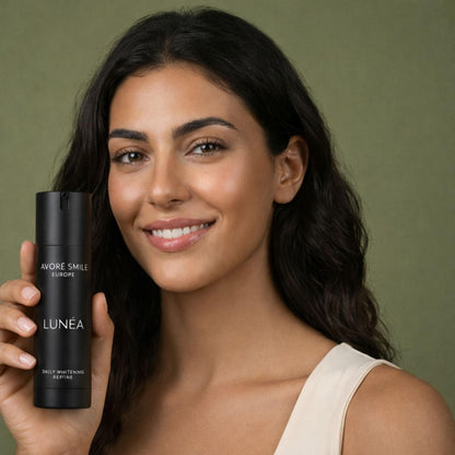 Female model smiling while holding Avoré Smile Lunéa bottle in studio